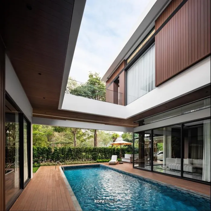 Lap pool in a courtyard wrapped by timber decking and glass walls