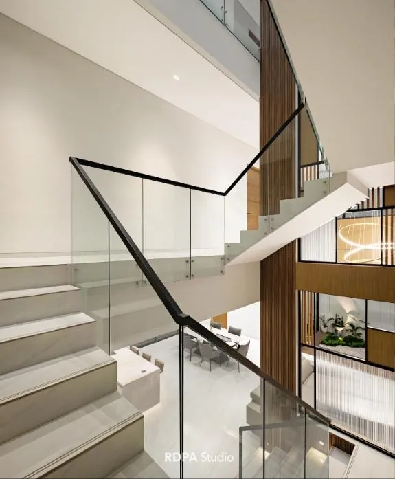 Open stair with a glass balustrade rising through a double height void